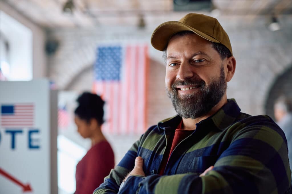 Confident US citizen at polling place on election day looking at camera.