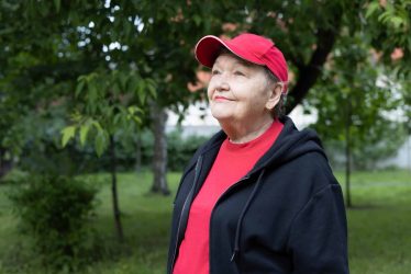 portrait of happy elderly woman in red cap and sport shirt
